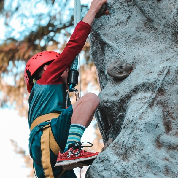 young boy top roping on artifical climbing wall