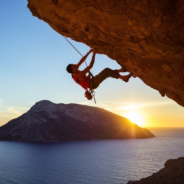 rock climber climbing overhang near ocean