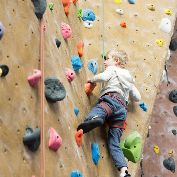 young boy climbing on indoor climbing wall
